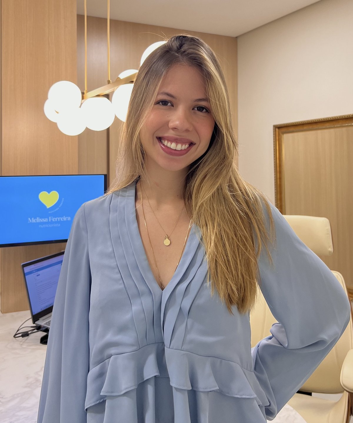 Melissa Ferreira, nutricionista, sorrindo em seu consultório em Uberlândia